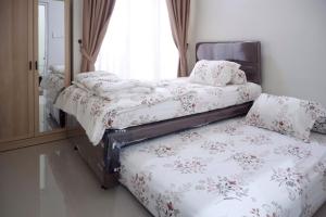 ein Schlafzimmer mit zwei Betten und einem Fenster in der Unterkunft Baturu Villa Kayana Regency D9 Dekat Jatim Park 3 in Batu