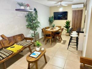 a living room with a couch and a table and chairs at Casa con alberca a 8 Min de Playa in Ixtapa
