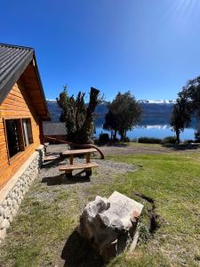 a picnic table and a rock next to a building at Costa Traful in Villa Traful