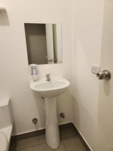 a white sink in a bathroom with a mirror at Family Tower in Lima