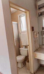 a bathroom with a toilet and a window and a sink at Hotel del valle in Ensenada +7 photos