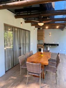 a dining room with a wooden table and chairs at Praia do Forte - Casa linda 3 quartos in Mata de Sao Joao