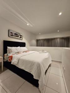 a bedroom with a large bed with white sheets at Embassy Garden Luxury in Accra +32 photos