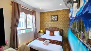 a bedroom with two beds and a painting on the wall at Milan Corner Hotel in Vung Tau