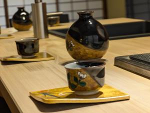 eine Gruppe von Vasen und Tassen auf einem Tisch in der Unterkunft Kanazawa Machiya Tong Poo in Kanazawa
