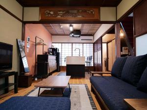 金沢市にある金澤町家 貸切古民家 東風のソファとテーブルのあるリビングルーム