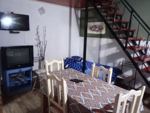 a dining room with a table and chairs and a television at Ma-Lu-Or 2 in Trelew