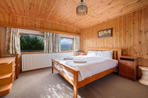 a bedroom with a bed in a wooden room at Elvira Ski Lodge in Jindabyne