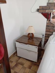 une table avec une lampe au-dessus d'un tiroir dans l'établissement LINDO APTO CENTRAL, QUASE ao LADO DO HOTEL NACIONAL CORUMBÁ -MS, à Corumbá 17 autres photos