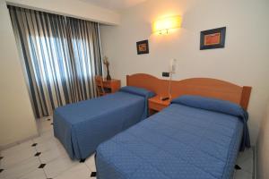 A bed or beds in a room at Hostal Goyma I