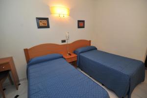 A bed or beds in a room at Hostal Goyma I