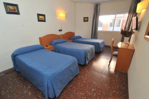 A bed or beds in a room at Hostal Goyma I