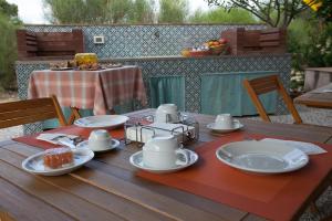 a wooden table with plates and dishes on it at Agriturismo Baglio Donna Santa in Dattilo