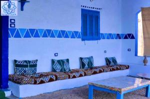 a living room with a couch with pillows at Asilah kato nubian guest house in Aswan