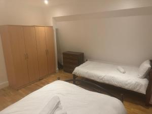 Habitación pequeña con 2 camas y armario en One bed room near Wembley stadium, en Preston