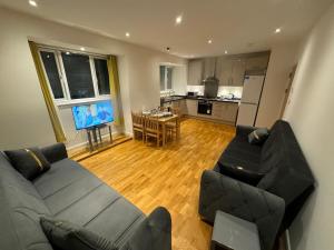 sala de estar con sofá y TV y cocina en One bed room near Wembley stadium, en Preston