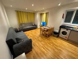 una sala de estar con un sofá y una mesa en One bed room near Wembley stadium, en Preston