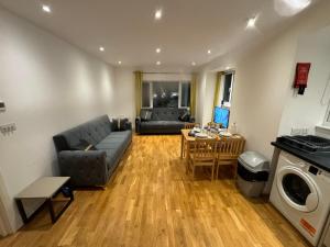 una sala de estar con un sofá y una mesa en One bed room near Wembley stadium, en Preston