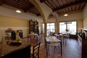 un restaurante con mesas y sillas en una habitación en Agriturismo Bagnaia en San Quirico dʼOrcia