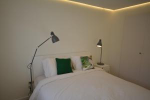 1 dormitorio con 1 cama blanca y 2 lámparas en Nogalera Boutique Apartment, en Torremolinos