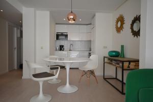 a kitchen and living room with a table and chairs at Nogalera Boutique Apartment in Torremolinos
