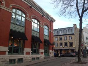 - un bâtiment en briques rouges avec des fenêtres donnant sur une rue dans l'établissement Condo Le 1000 - Quebec, à Québec