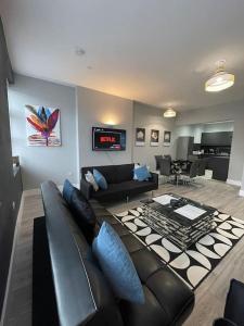 カーディフにあるLuxury 2 Bed City Centre Duplex with High Ceilingsのリビングルーム(黒い革張りのソファ、テーブル付)