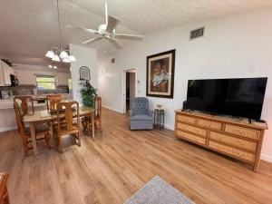 a living room with a dining table and a flat screen tv at Stylish budget friendly retreat! in Lake Placid