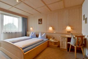 1 dormitorio con cama, escritorio y ventana en Ferienwohnung Kainer Carina, en Ried im Zillertal