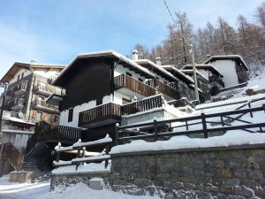 Una casa con nieve en el techo. en Petit Maison - Valtournenche, en Valtournenche