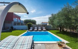 a swimming pool in a yard with chairs and an umbrella at Villa Mediteranea in Umag