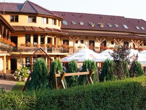 a building with tables and umbrellas in front of it at Słoneczny Dwór in Krynica Morska