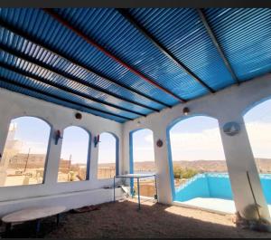 a room with three windows and a blue ceiling at Asilah kato nubian guest house in Aswan