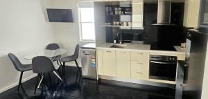 a kitchen with a table and chairs and a sink at Fitzroy Lodge Cowra in Cowra