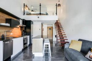 eine Küche und ein Wohnzimmer mit einer Couch und einer Treppe in der Unterkunft Condo moderne, escapade vacance, vue sur montagnes in Mont-Tremblant