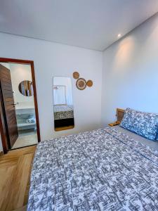 a bedroom with a large bed and a mirror at Pousada Solarium in Canoa Quebrada