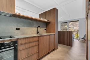 a kitchen with wooden cabinets and a sink at Byadbo 5 in Thredbo