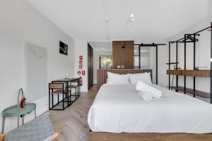 a bedroom with a large white bed and a table at Byadbo 5 in Thredbo