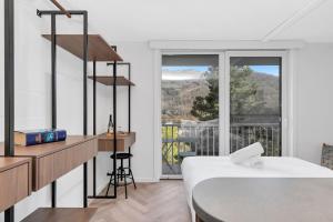 a white room with a bed and a balcony at Byadbo 5 in Thredbo