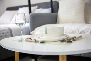 a white coffee table with a glass of wine and a plate at Studio chic Nantes, calme assuré in Nantes