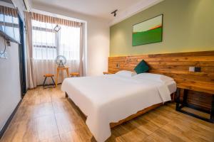 una camera con un letto bianco e una parete in legno di Tianmenshan Loft Art Inn a Zhangjiajie