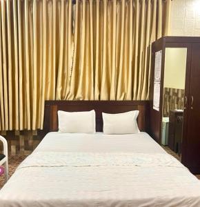 a bed with two white pillows in a bedroom at Lucky 1 Hotel in Trà Vinh