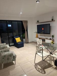皮门特尔Lindo Departamento con Terraza Vista al Mar的配有电视、桌椅的客厅