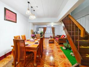 a dining room with a table and chairs and a staircase at Aphilapa House in Chiang Mai +40 photos