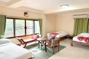 a room with two beds and a table and chairs at SK House 2 in Chiang Mai +55 photos