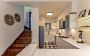 a kitchen with a staircase leading up to a loft at La Verona by The Blue Kite - 2 & 3 BHK Villas in Assagao with Private Pool, Garden, Caretaker, Kitchen & Security in Assagao
