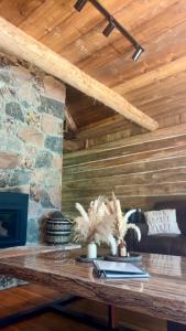 ein Holztisch in einem Raum mit einer Steinwand in der Unterkunft John Wayne Cedar Oasis in Cookstown