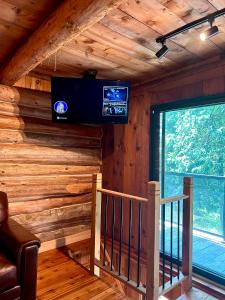 ein Zimmer mit einer Treppe und einem Fernseher an der Wand in der Unterkunft John Wayne Cedar Oasis in Cookstown