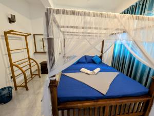 a bedroom with a bed with a mosquito net at Costels Mirissa in Mirissa