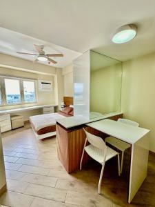a room with a table and chairs and a bed at Voice activated studio condo unit at One Regis Megaworld, JK Modern Nest in Bacolod